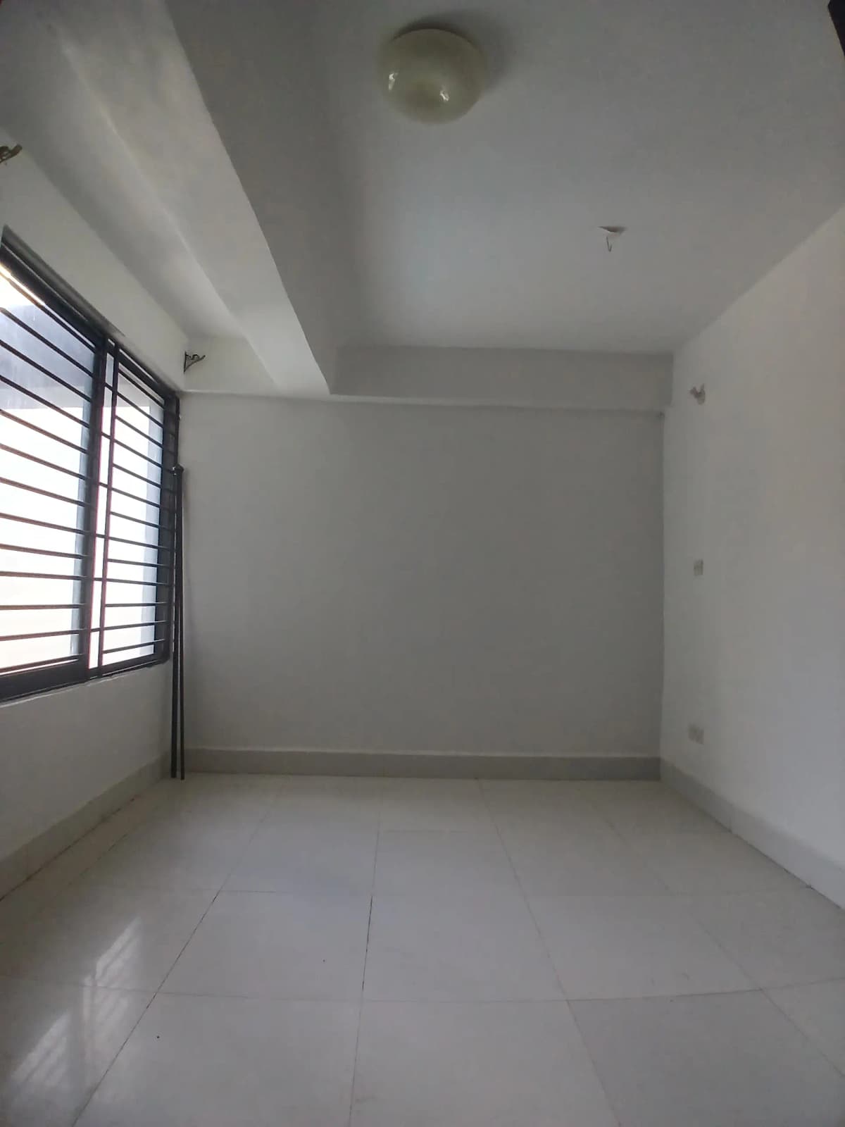 Bare bedroom with window, minimal furnishings, polished floor