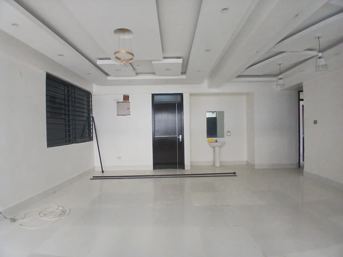 Spacious empty living room with coffered ceiling and elevator entrance