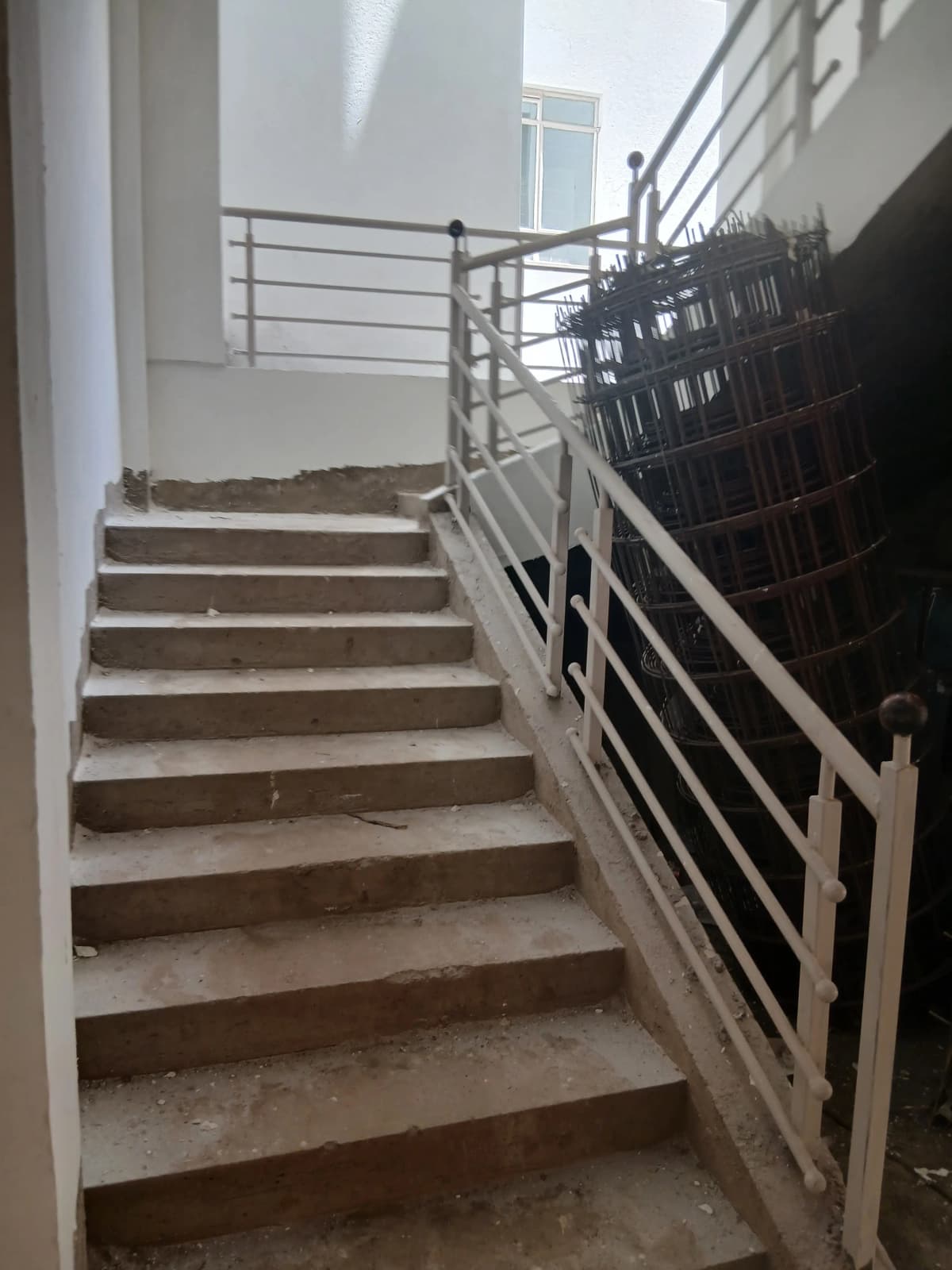 Interior staircase with metal railings and natural light