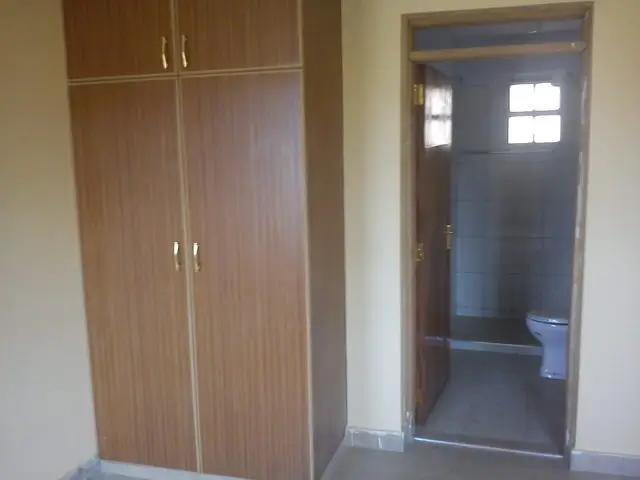 Bedroom with built-in wooden wardrobes and en-suite bathroom access