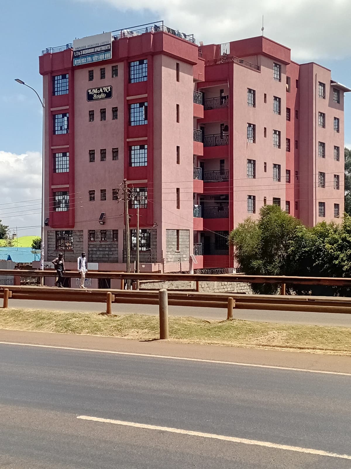 Red multi-story residential apartment building with balconies