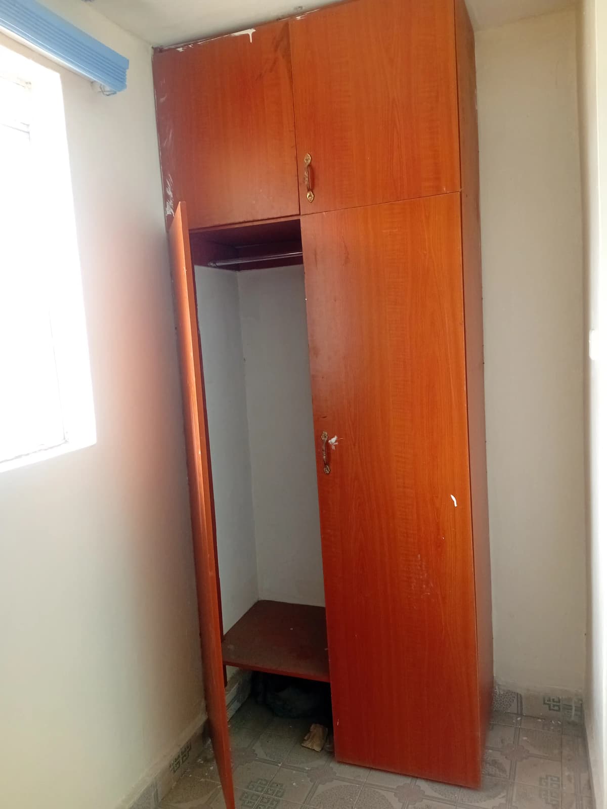Compact red-doored storage closet with built-in shelving