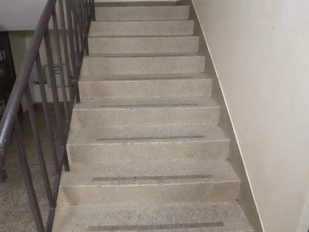 Internal staircase with metal railing and concrete steps