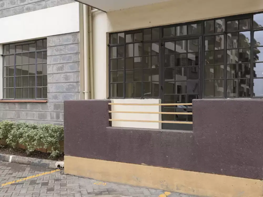 Modern building facade with dark-framed windows and perimeter wall