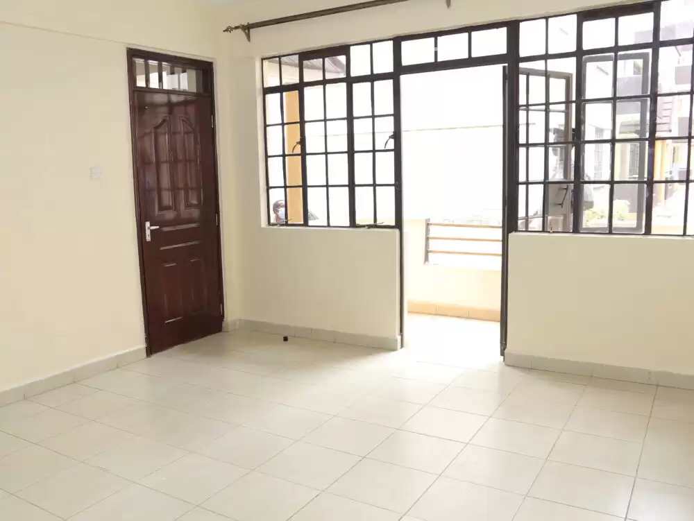 Spacious living room with tiled flooring and natural light