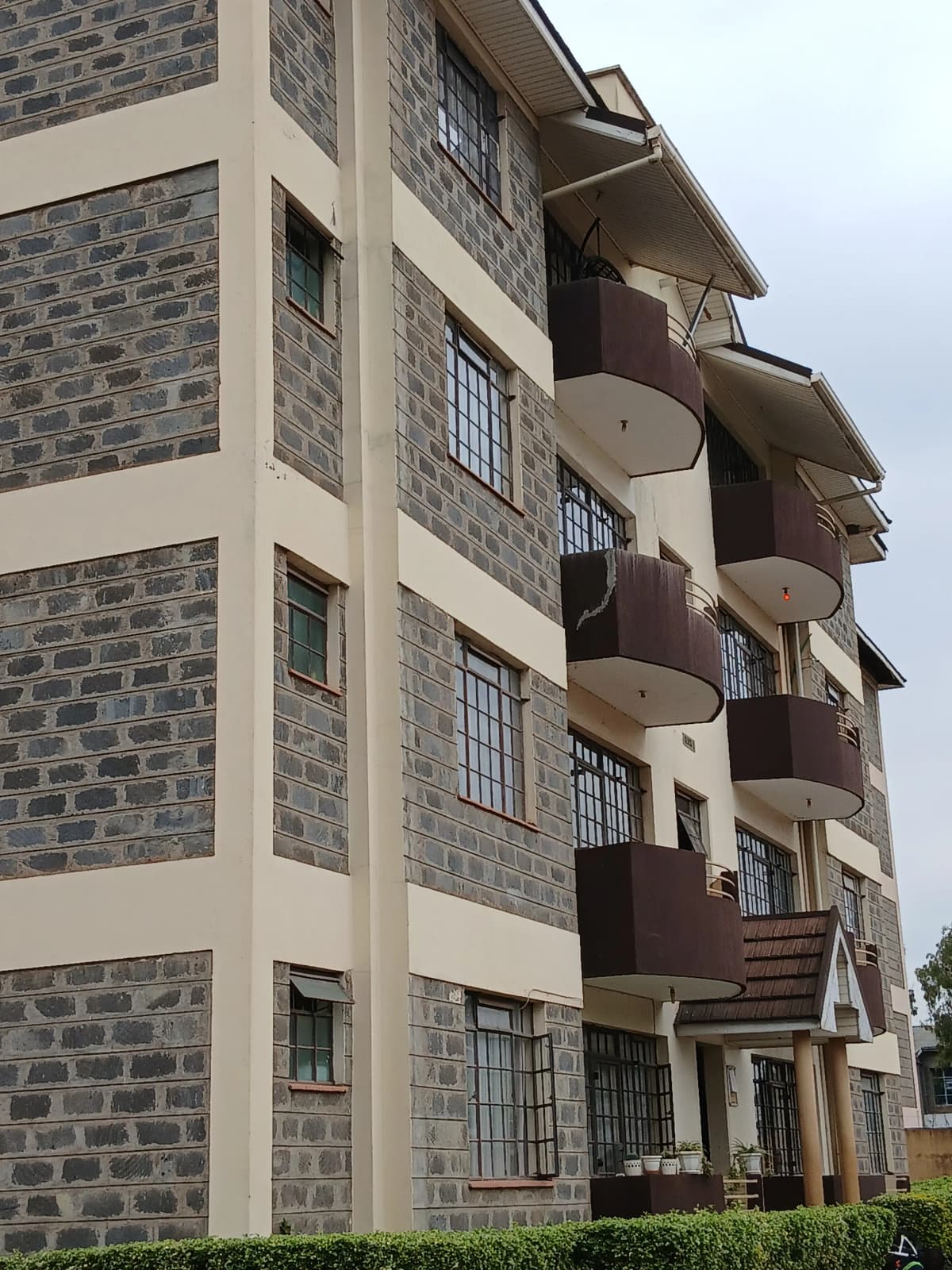 Multi-story residential building with stone facade and balconies
