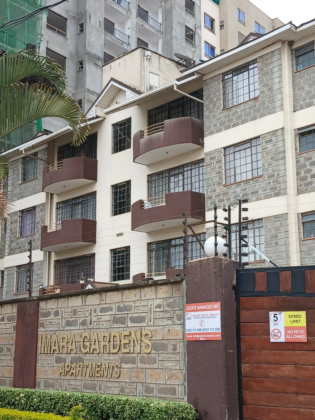 Mid-rise apartment building facade with brown balconies and stone cladding