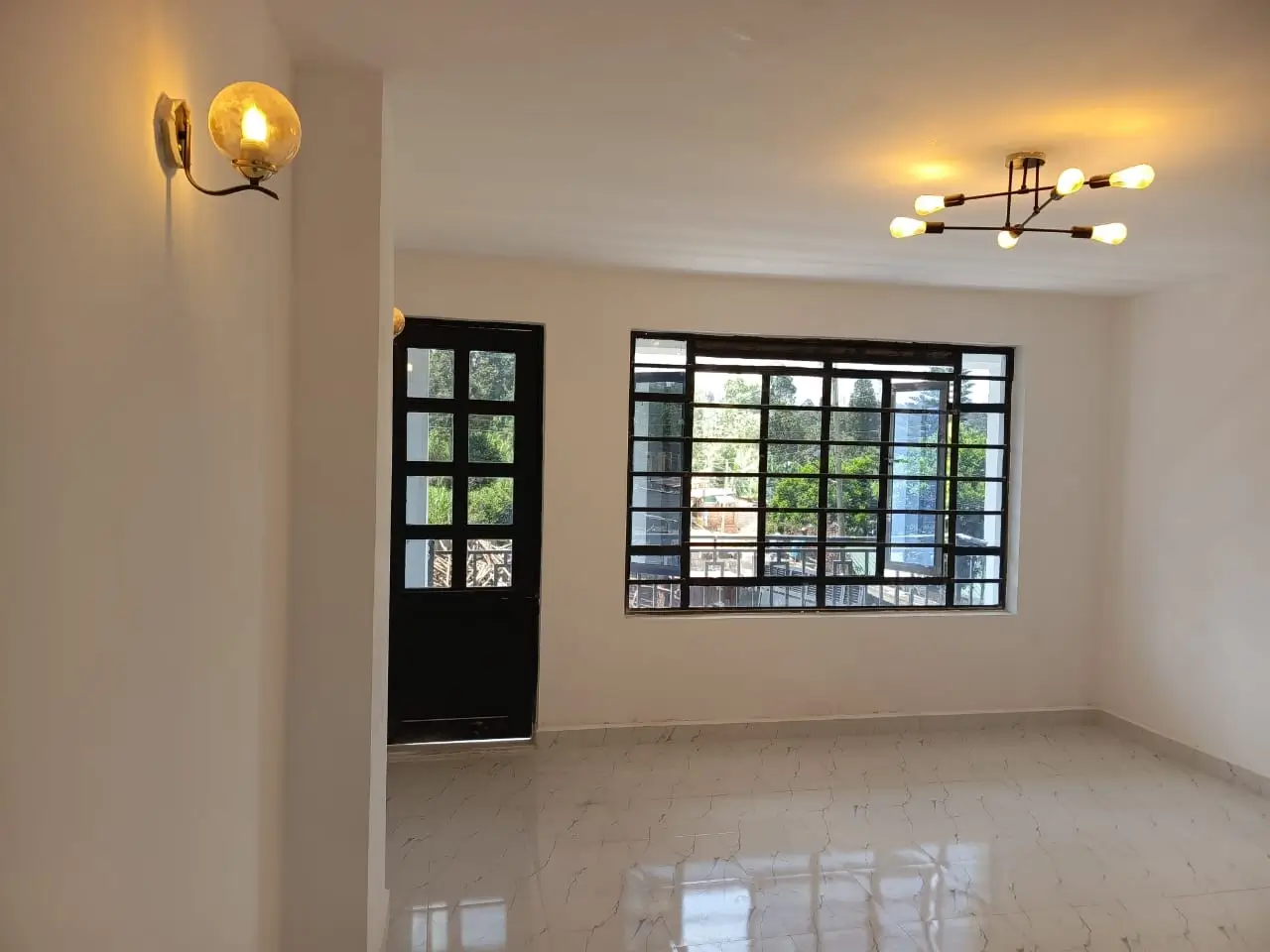 Empty living room with polished floor and decorative wall lighting
