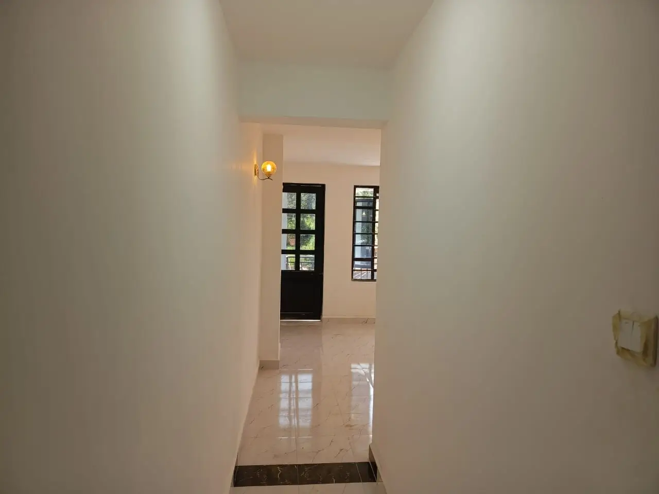 Clean corridor with polished floor and wall sconces