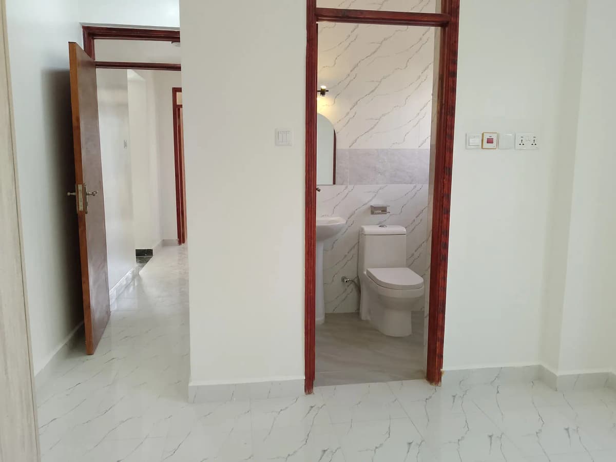Modern bathroom with marble flooring and burgundy door frame