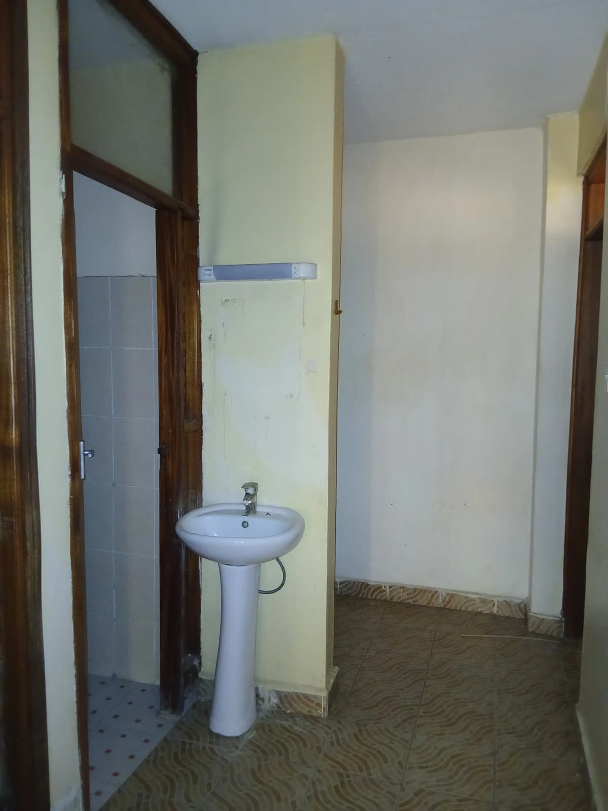 Basic bathroom with pedestal sink and tiled flooring