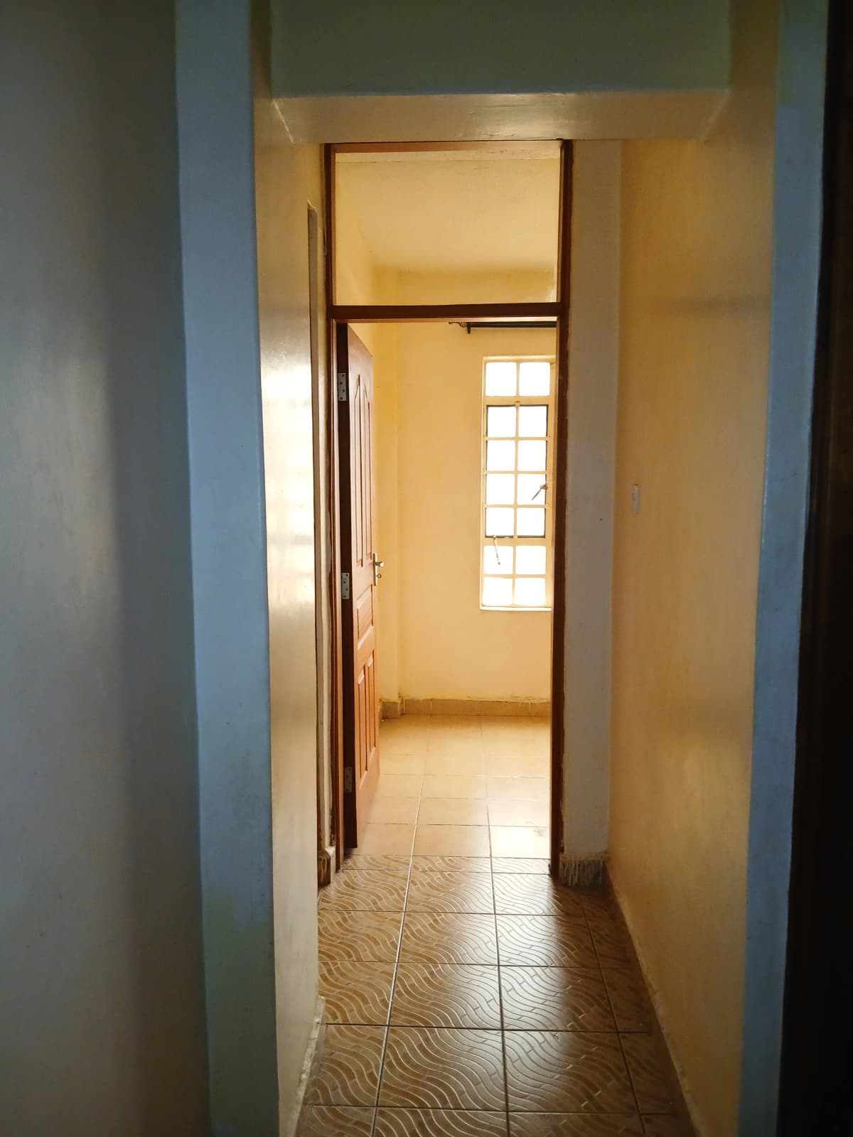 Narrow hallway with tiled floor and natural light