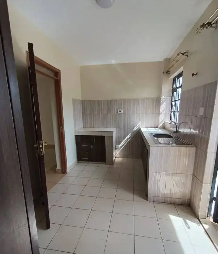 Kitchen with built-in oven and washing machine on right