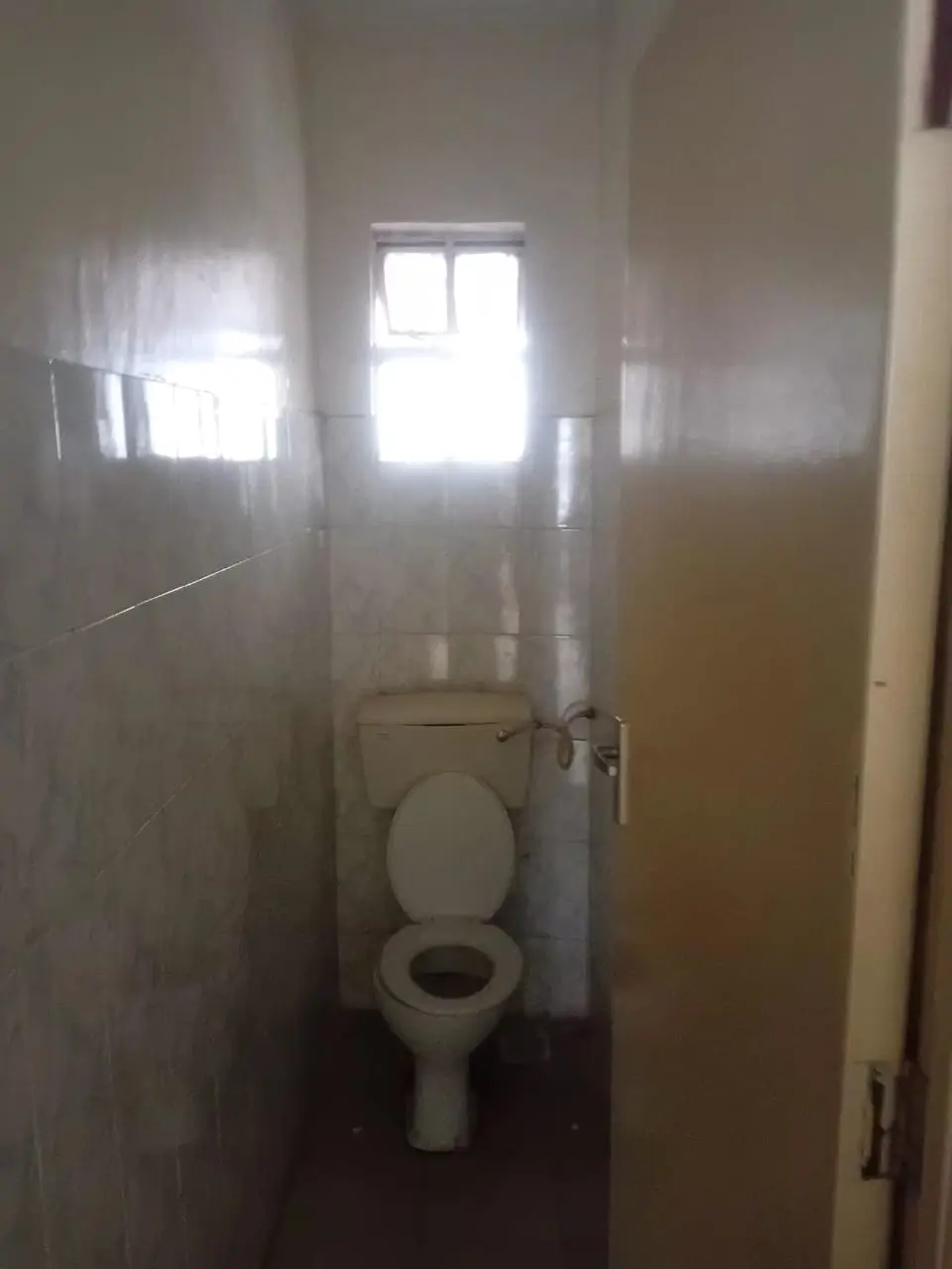 Compact toilet cubicle with natural light from small window