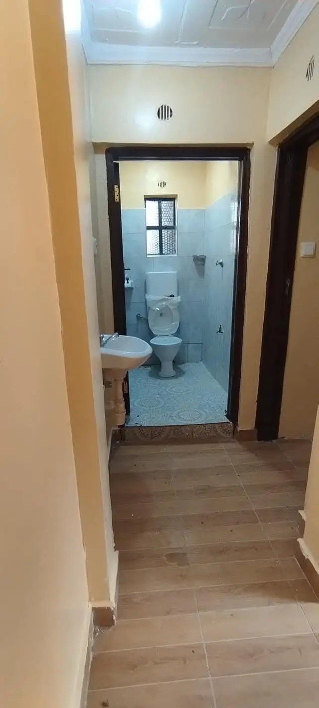 Compact bathroom with toilet and pedestal sink visible