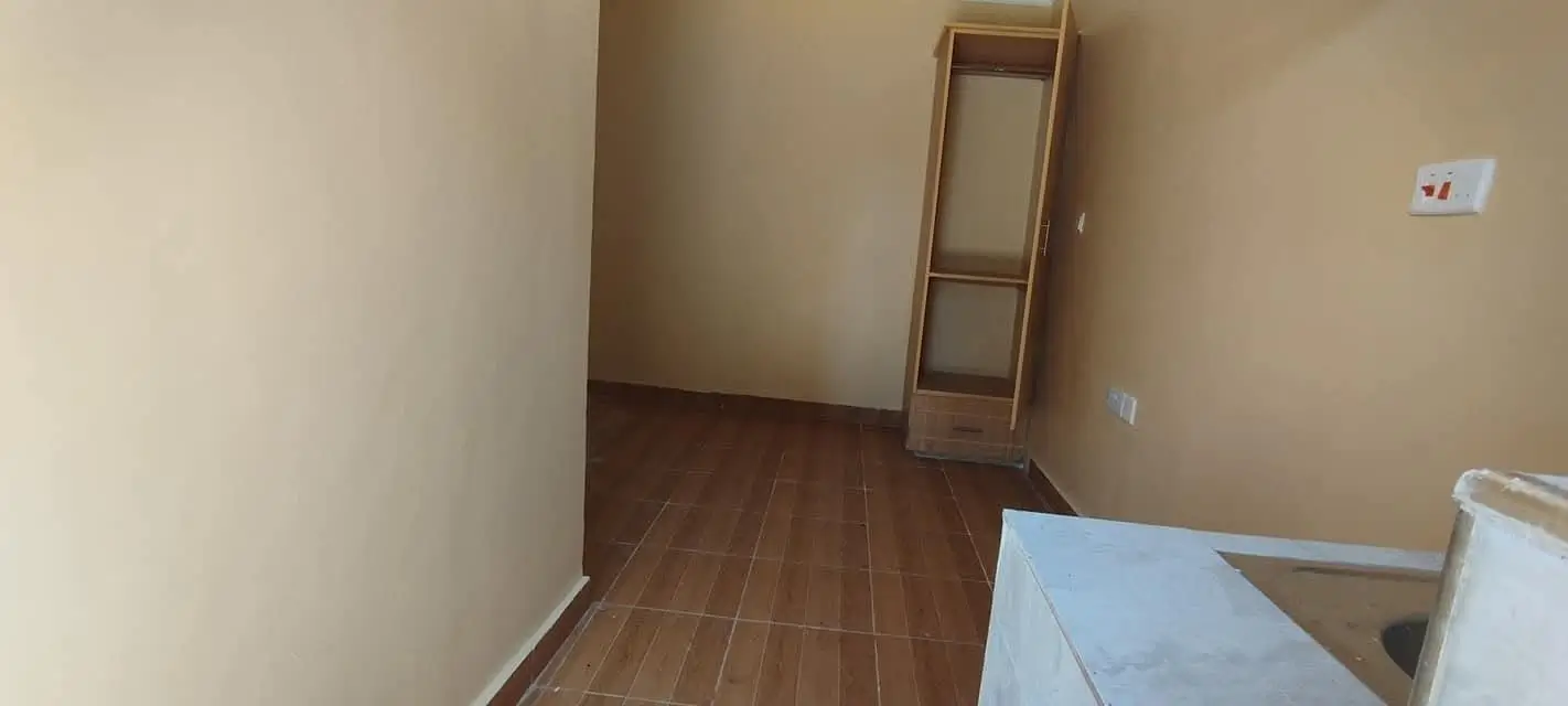 Unfurnished bedroom with wooden flooring and basic fixtures