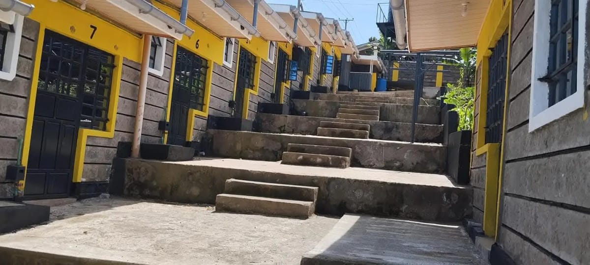 Compound entrance with yellow gates and tiered steps