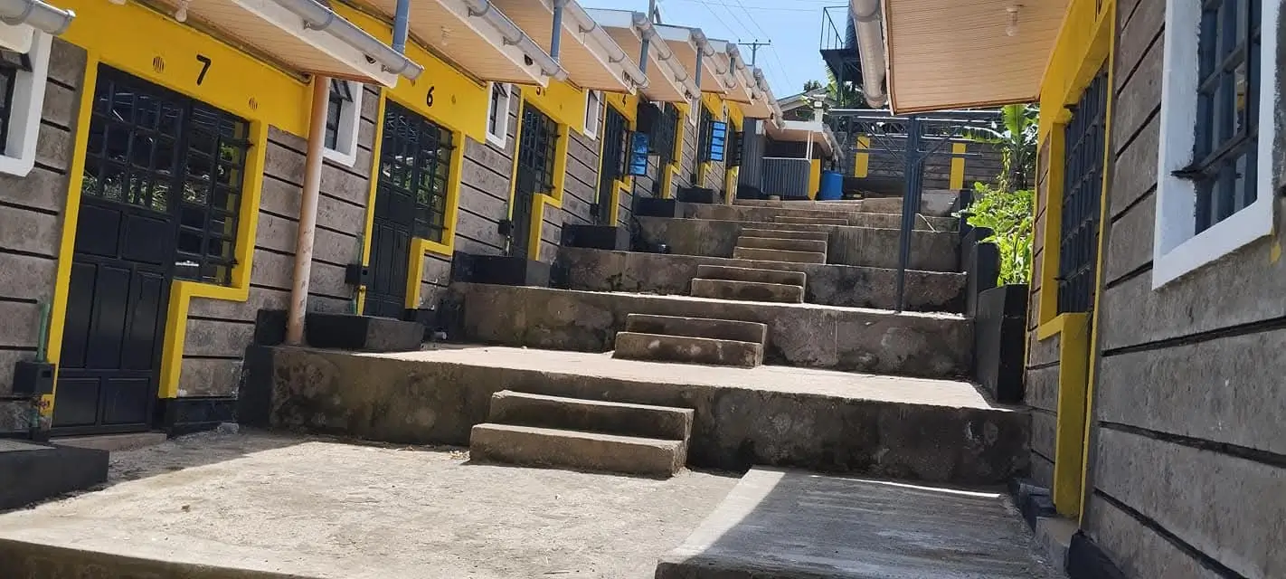Compound entrance with yellow gates and tiered steps
