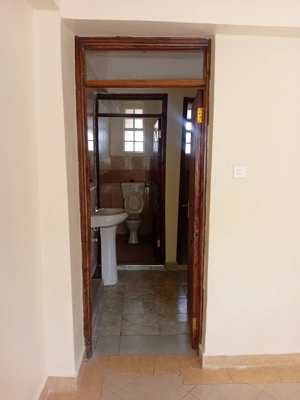 Bathroom with pedestal sink and tiled flooring