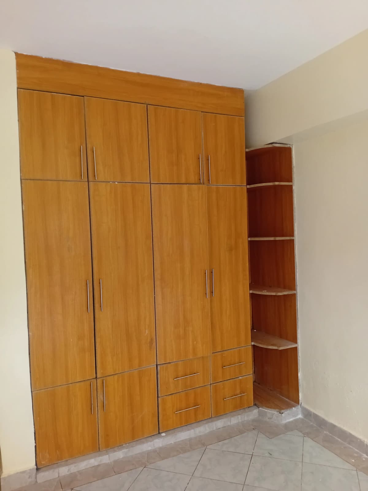 Bedroom with large wooden built-in wardrobe and shelving