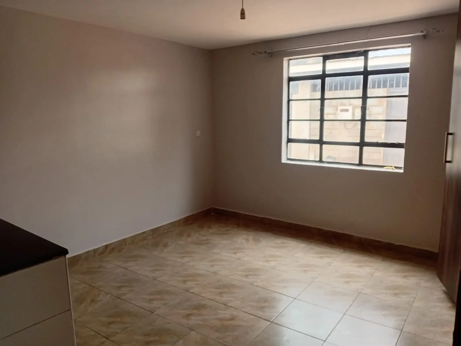 Spacious living room with tiled flooring and natural light