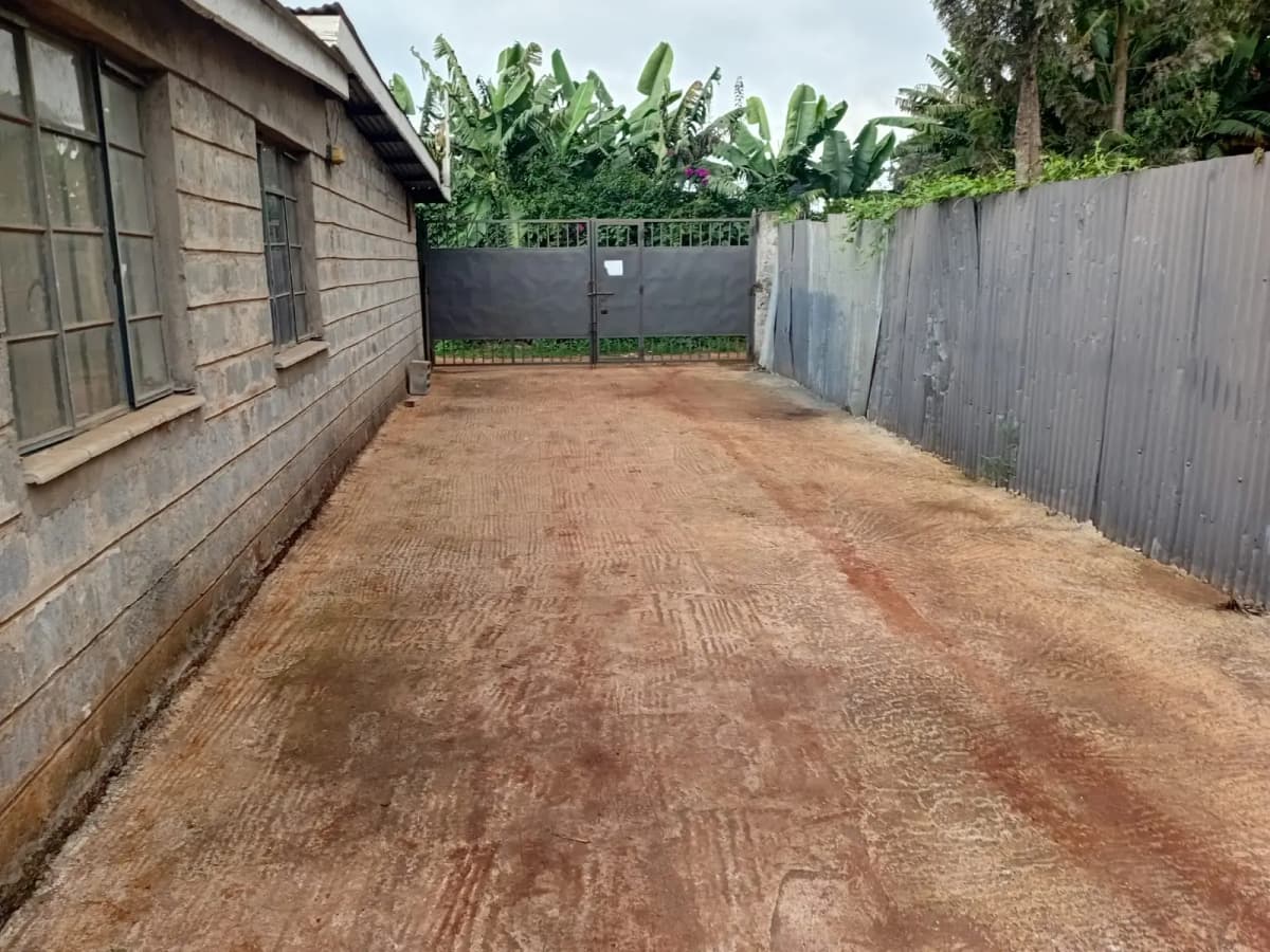 Spacious unpaved parking area with metal gates