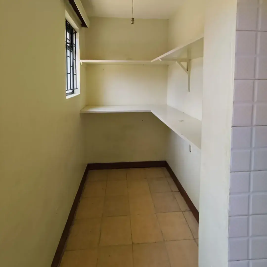 Narrow utility room with built-in shelving and small window