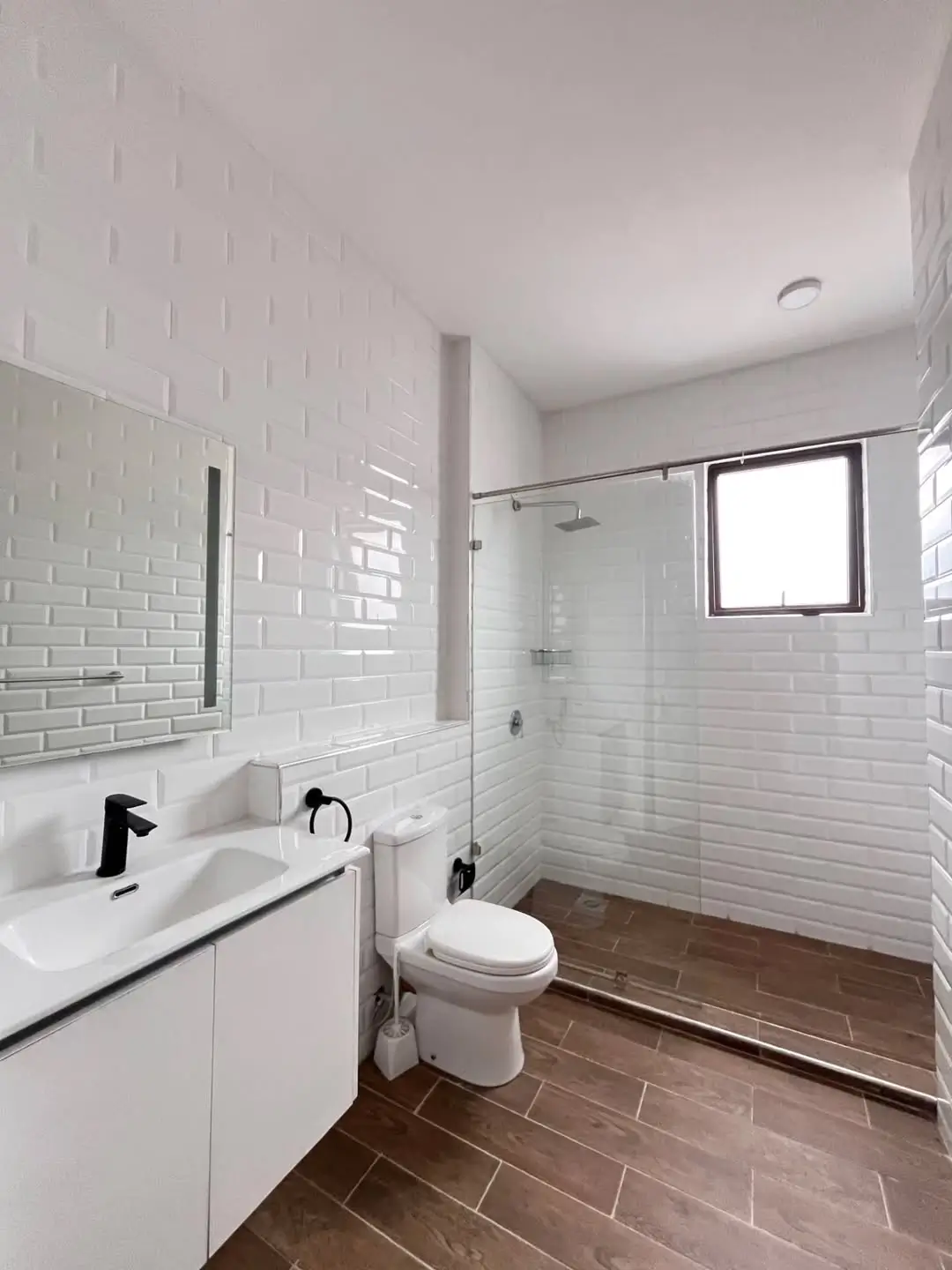 Modern bathroom with white subway tiles, glass shower enclosure