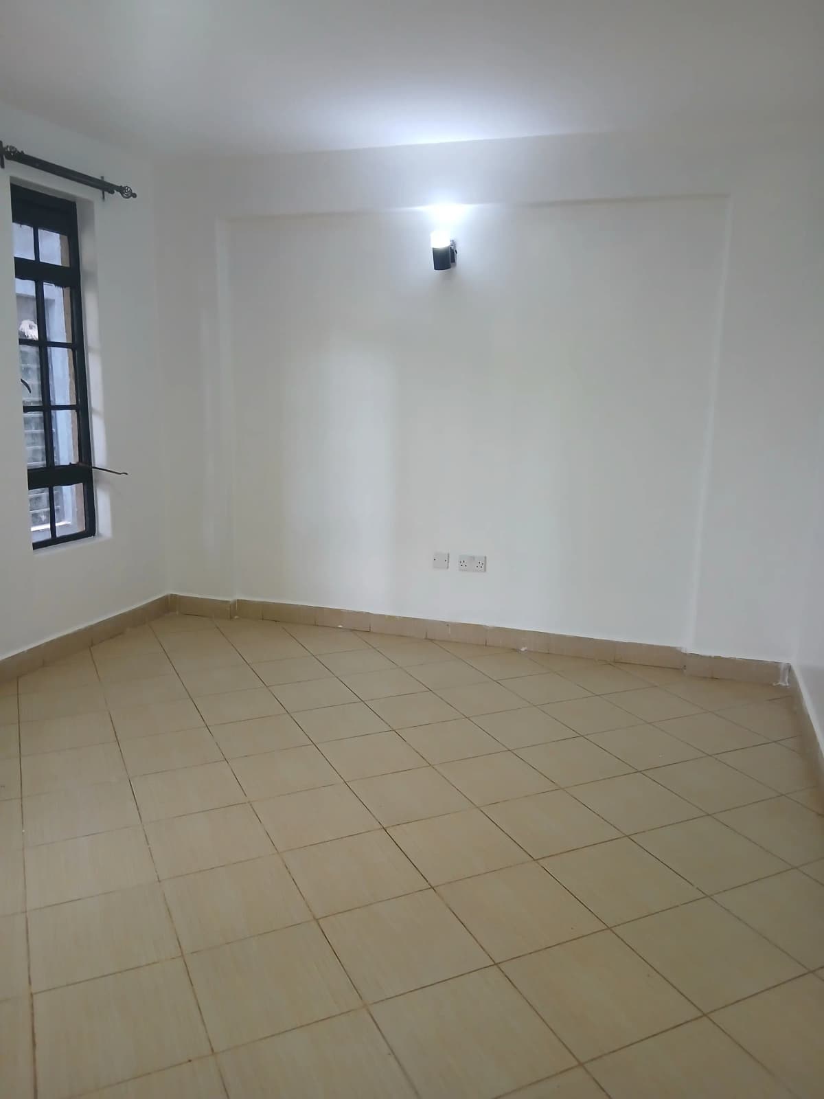 Empty bedroom with tiled floor and single window