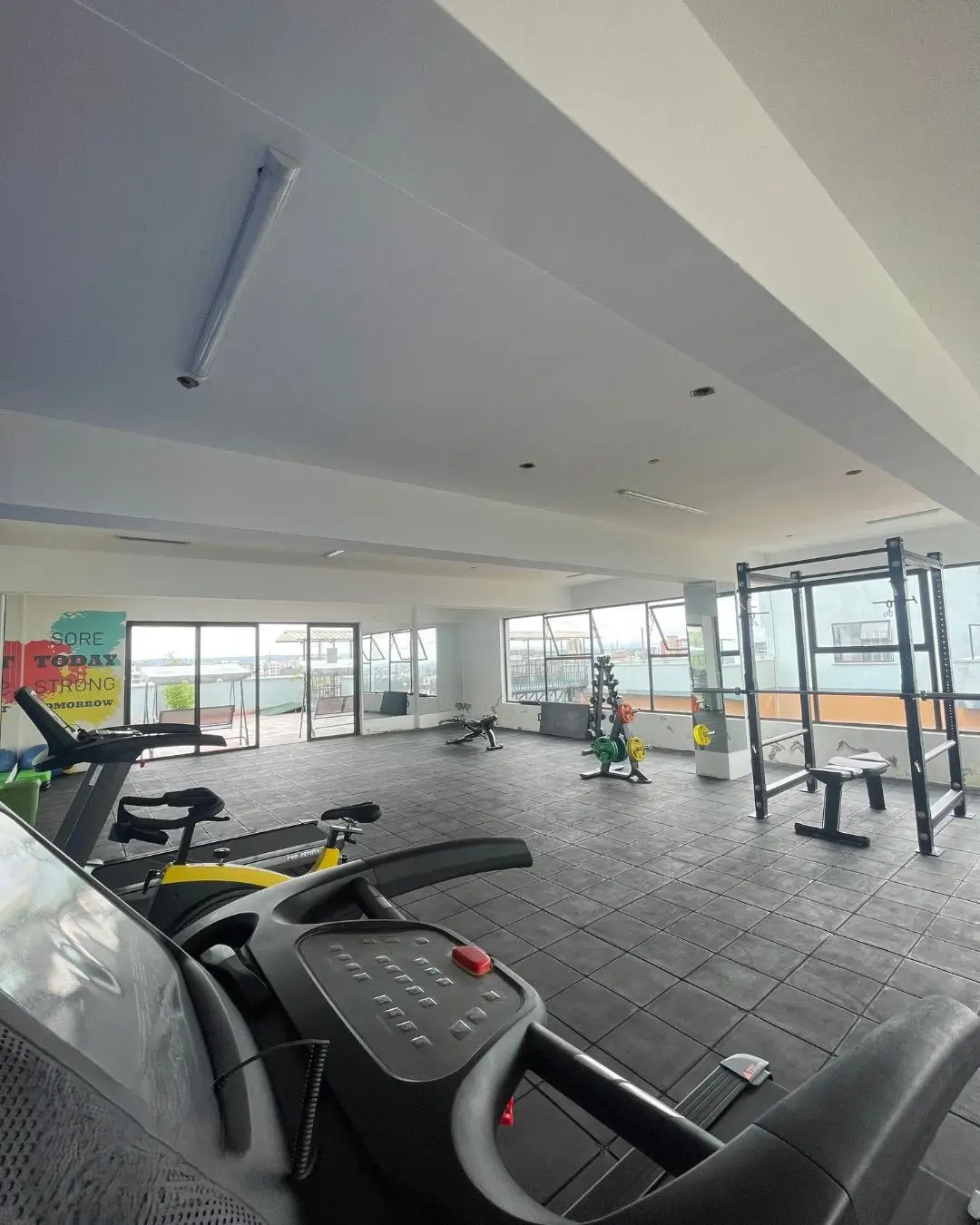 Spacious gym with treadmills, exercise bikes, large windows