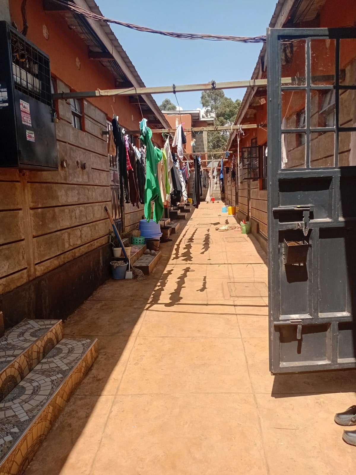 Narrow residential alleyway with clothesline and modest housing units