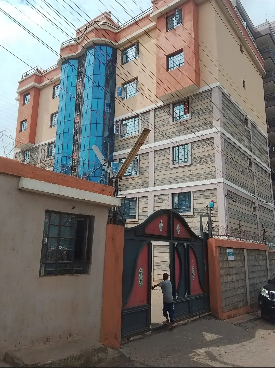 Multi-story residential building with red gate entrance