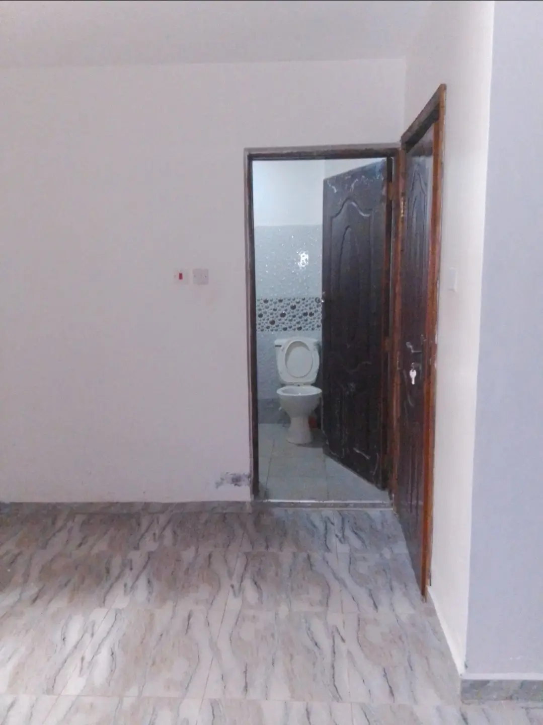 Bathroom with toilet visible through open doorway