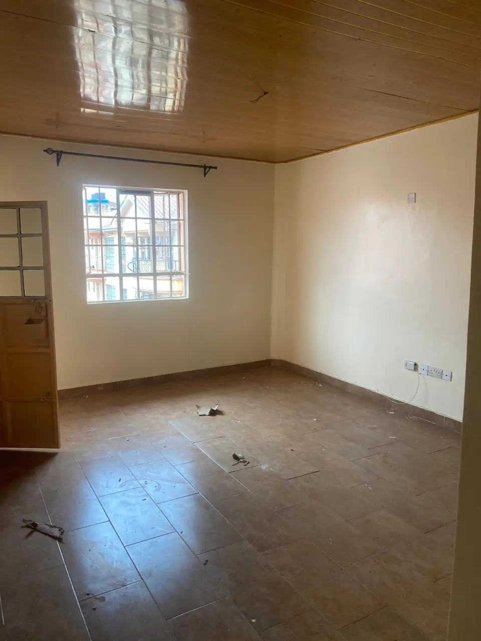 Empty living room with tiled floor and large window