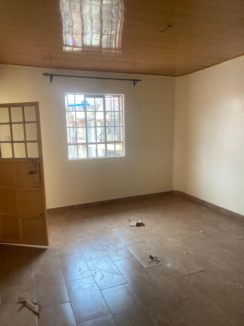 Empty bedroom with tiled floor and barred windows