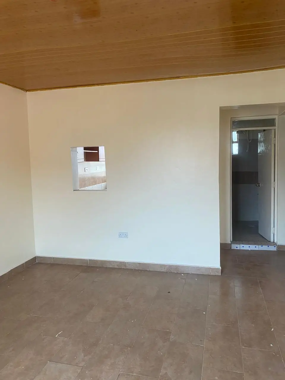 Empty living room with brown ceiling and tiled floor