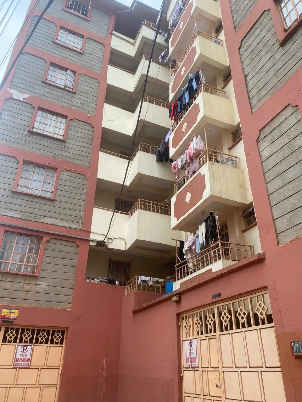 Multi-story residential building facade with red and cream paint