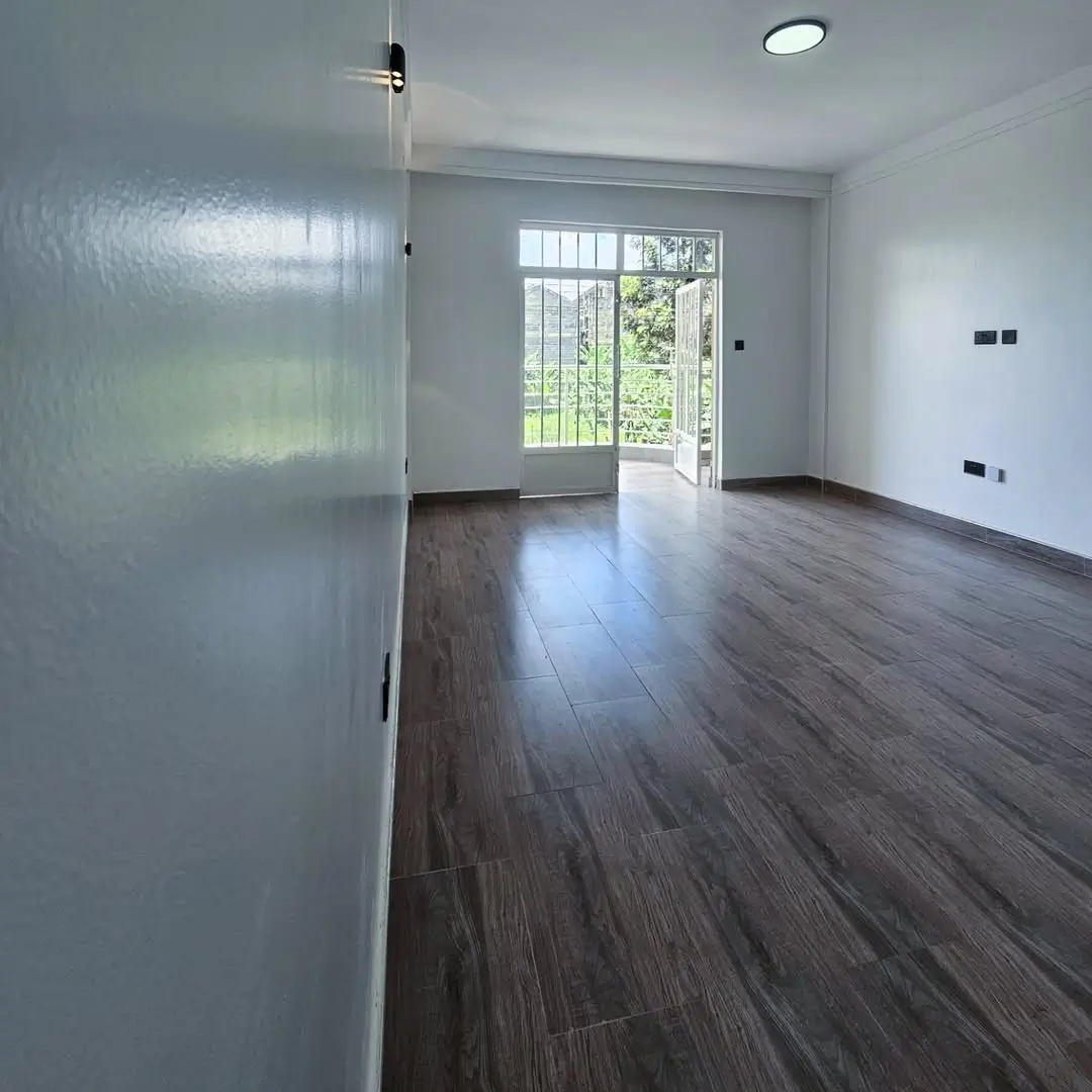 Spacious living area with dark wood flooring and garden access