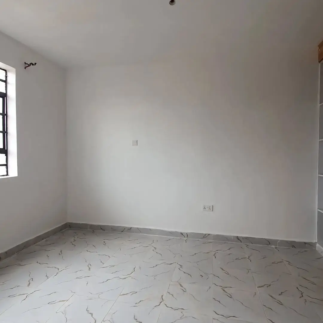 Unfurnished bedroom with marble-effect flooring and window light