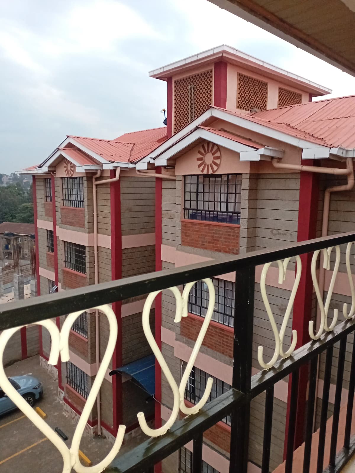 Multi-story residential building viewed from balcony with railing