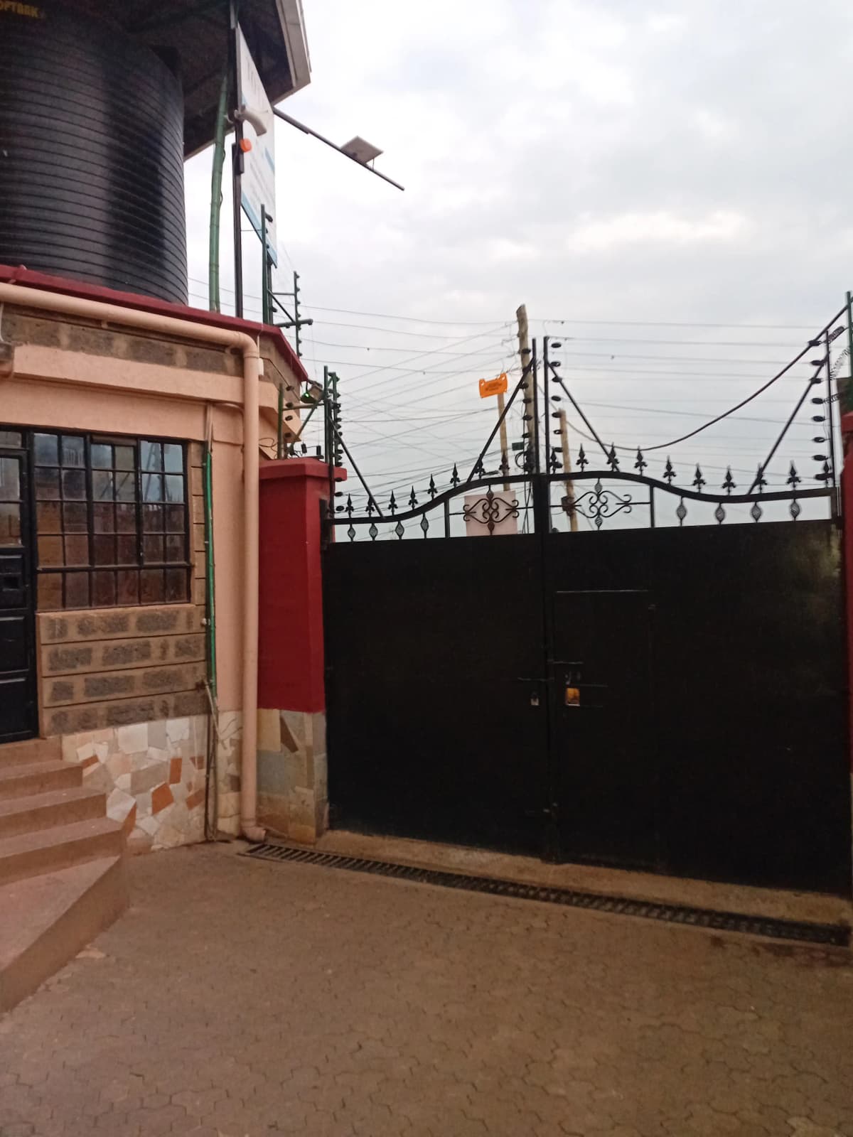 Property entrance with ornate black gate and brick facade