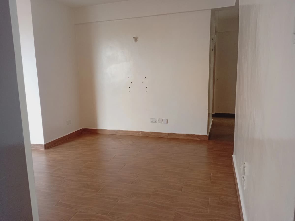 Empty living room with wooden floor and neutral walls