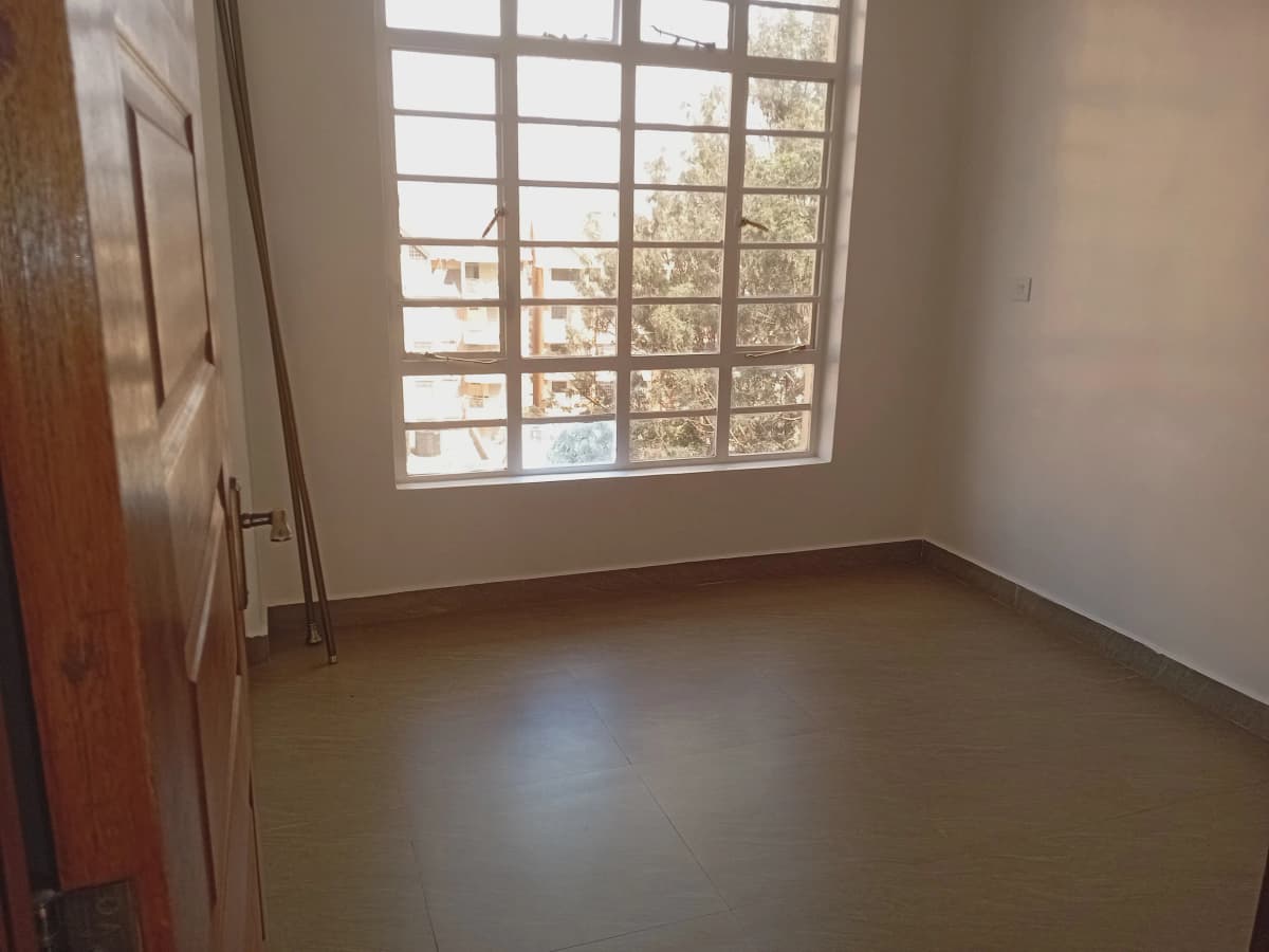 Bare bedroom with large window and polished concrete floor