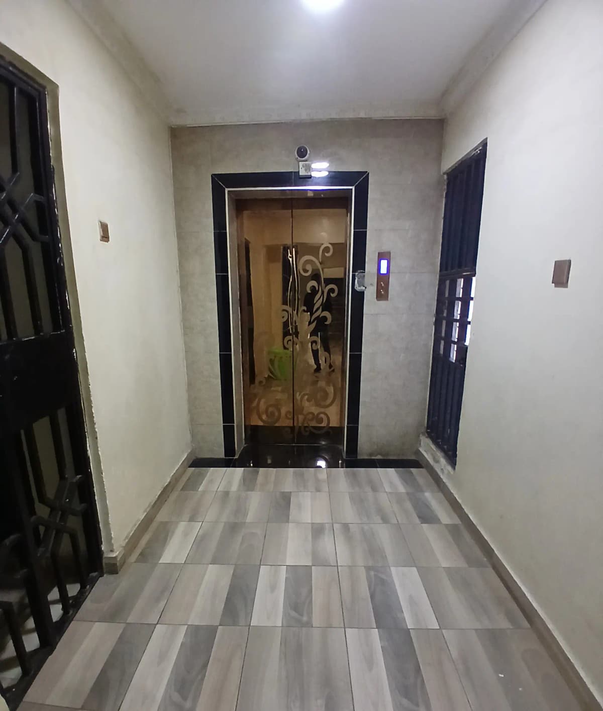 Building entrance lobby with elevator and striped tile flooring