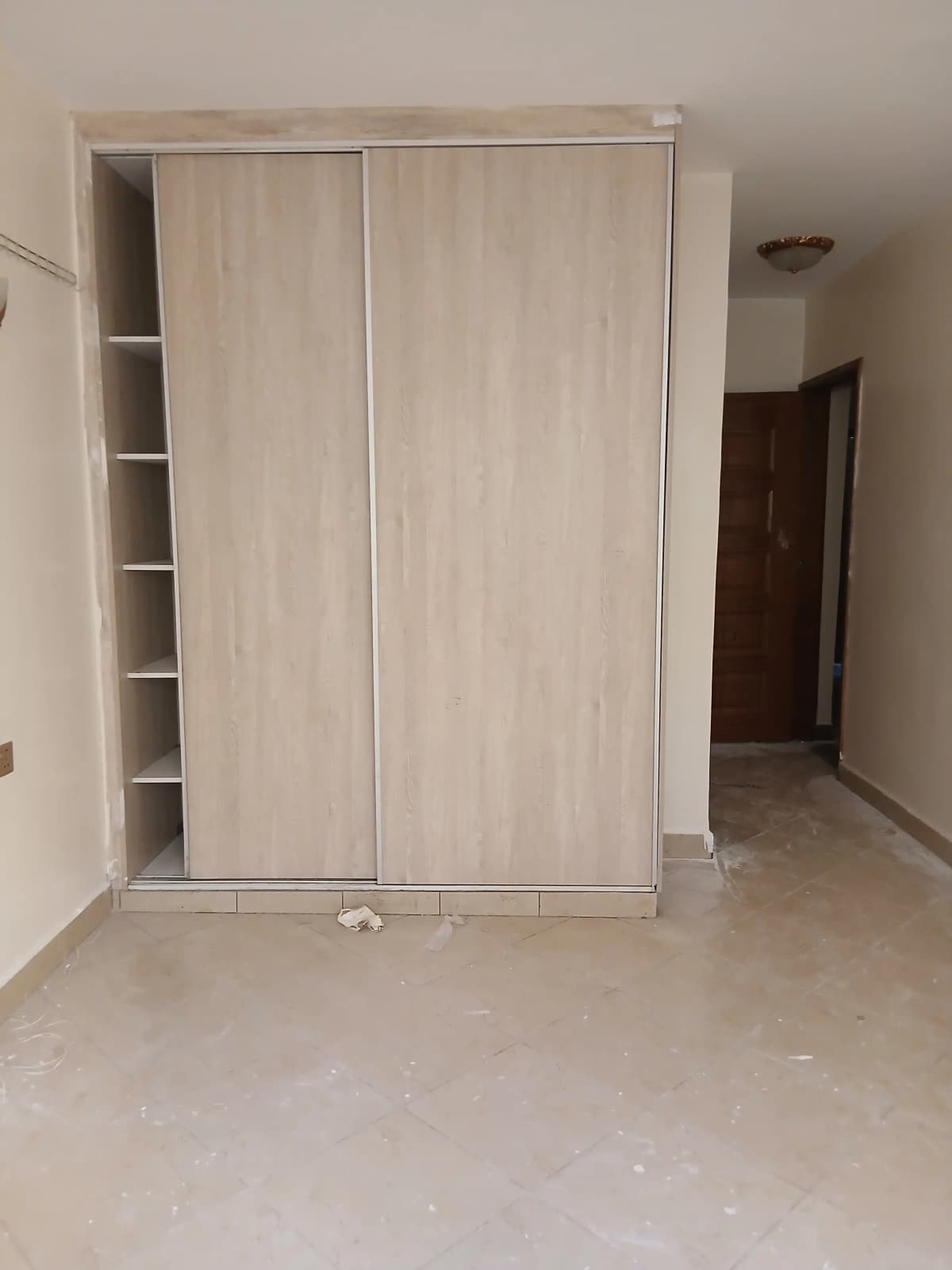 Spacious bedroom with built-in sliding wardrobe and shelving