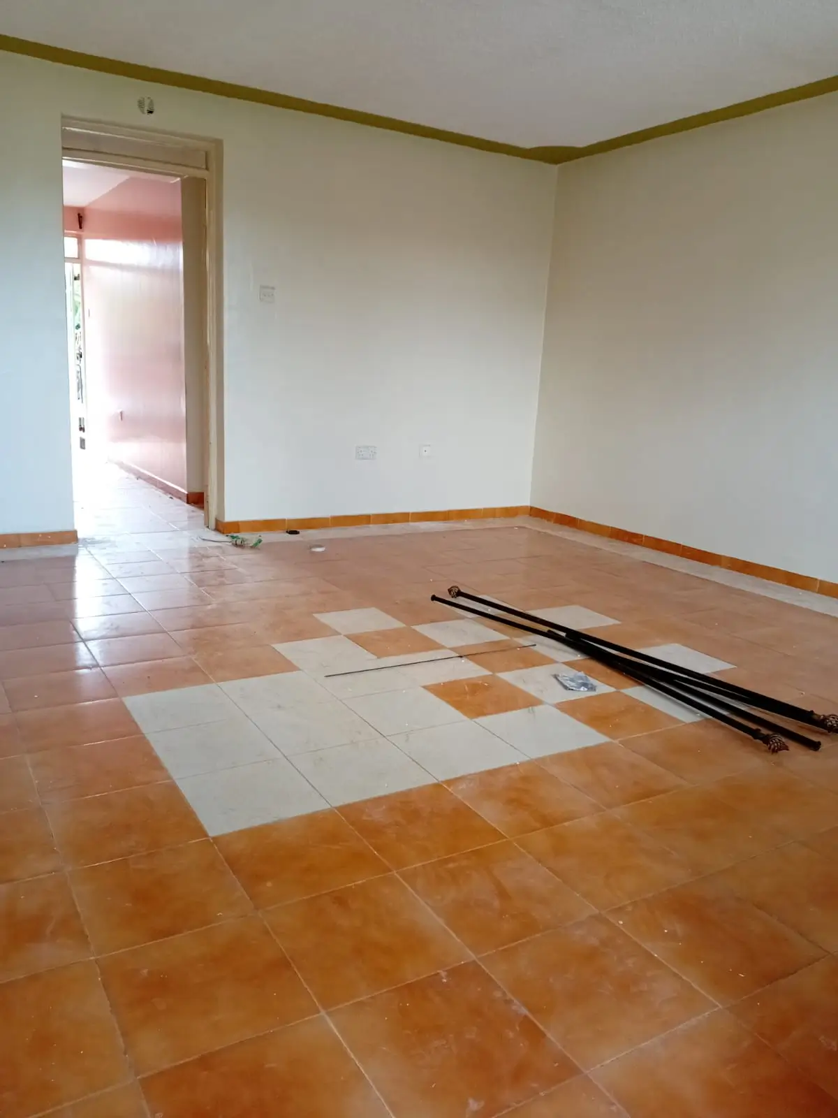 Empty living room with terracotta tile flooring and doorway