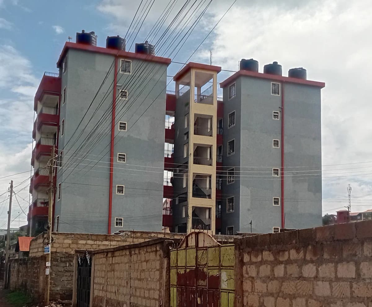 Multi-story residential apartment buildings with red-trimmed facade