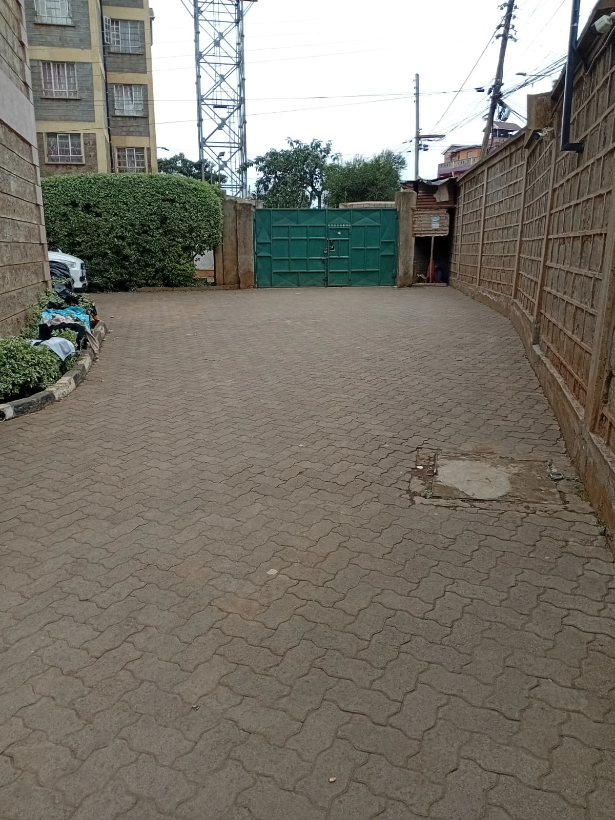 Paved compound parking area with green gate entrance