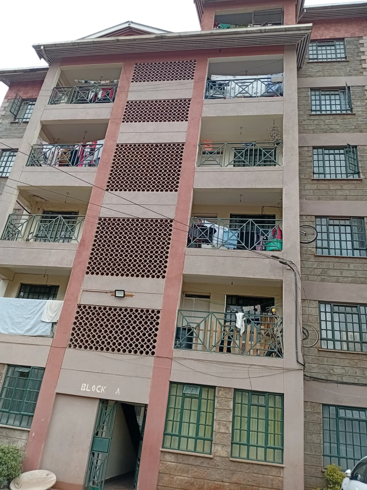 Multi-story residential building facade with balconies and green doors