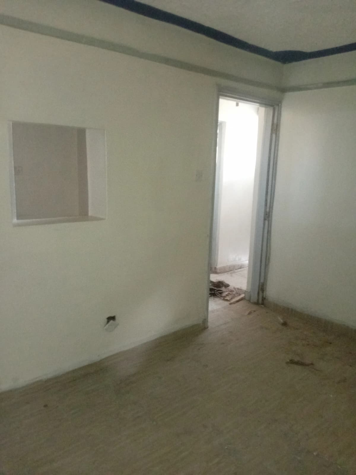 Unfurnished bedroom with window and bare concrete floor